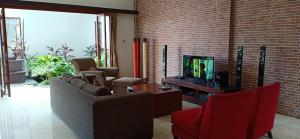 ein Wohnzimmer mit Sofas und einem Flachbild-TV in der Unterkunft Villa Aamoda in Canggu