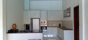 a large kitchen with white cabinets and appliances at Villa Aamoda in Canggu