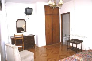 a bedroom with a bed and a dresser and a mirror at Hotel Primavera in Monte Real