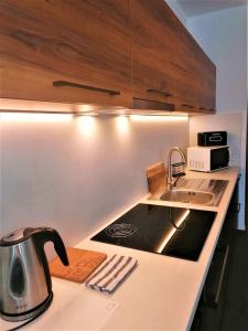 a kitchen with a sink and a stove top oven at Apartman 11 MyMara in Bešeňová +16 photos