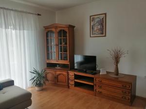 a living room with a tv and a wooden entertainment center at Kuća za odmor - My Soul in Šibenik