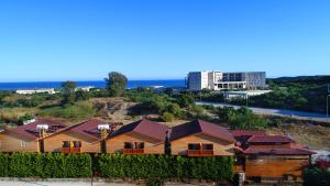 a group of houses on a hill next to the ocean at Dufa Bungalow Hotel in Demre