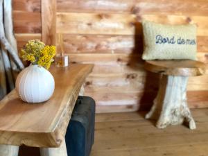 un vase de fleurs sur une table en bois avec un tabouret dans l'établissement A Casetta, à Pianottoli-Caldarello