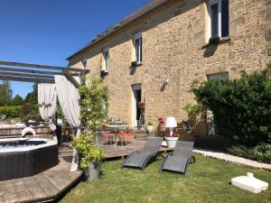 a garden with chairs and a table and a building at Le Clos des Bories in Sarlat-la-Canéda