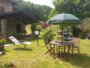 een tafel en stoelen met een parasol in de tuin bij B&B il Bagarello in Palazzuolo sul Senio