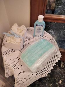 stolik z butelką mydła i pojemnik z ręcznikami w obiekcie CHRYSSA - ΧΡΥΣΑ w mieście Patras