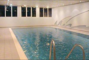 a swimming pool with blue water in a building at Ferienwohnanlage Brünnstein Wohnung 54 in Oberaudorf