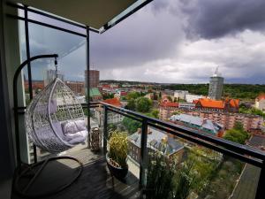 een balkon met een schommel en uitzicht op de stad bij Walowa Tower Apartments in Gdańsk