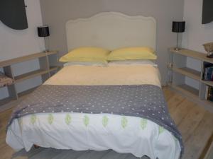a bed in a bedroom with two pillows at Hexagonal Tower for 2 with shared pool in Semur-en-Auxois