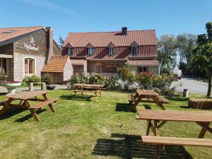 un groupe de tables de pique-nique devant un bâtiment dans l'établissement Au Cheval Noir, à Quaëdypre