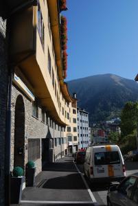 a white van parked on a street next to a building at Apartaments Del Meligar in Encamp