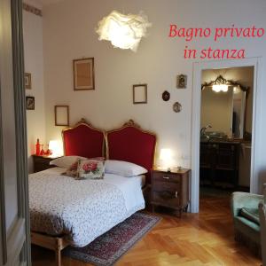 Schlafzimmer mit einem Bett mit einem roten Kopfteil und einem Spiegel in der Unterkunft Residenza Rubbiani - Fermata Fiera e Rizzoli in Bologna