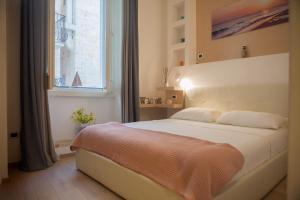 Un dormitorio con una gran cama blanca con ventana. en Terra d'Acqua, en Monopoli