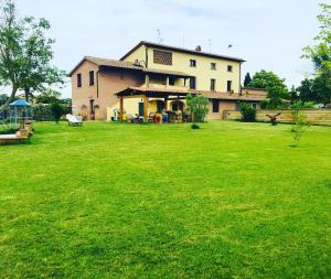 um grande pátio verde com uma grande casa em B&B La Toscanina em San Miniato