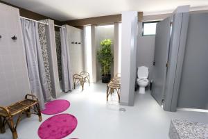 a bathroom with a toilet and a pink rug at HI Setubal - Pousada de Juventude - CASA DO LARGO in Setúbal