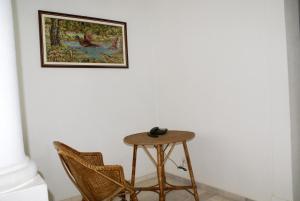 a table and two chairs and a picture on the wall at Hotel Primavera in Monte Real