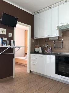 La cuisine est équipée de placards blancs et d'un four avec plaques de cuisson. dans l'établissement Apartment Kristina, à Novalja