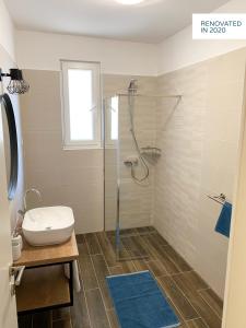 La salle de bains est pourvue d'une douche, de toilettes et d'un lavabo. dans l'établissement Stone & Salt Getaway Home, à Šimuni
