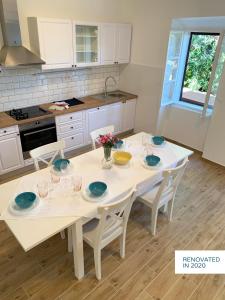 席烏倪的住宿－Stone & Salt Getaway Home，厨房配有白色桌子和蓝色餐具