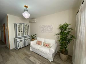 sala de estar con sofá blanco y planta en Casa Maeva en Tejeda