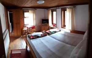 1 dormitorio con 1 cama grande de madera en una habitación en Sarafova Guest House, en Koprivshtitsa