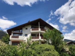 a building on a hill with trees in front of it at Casa Spel Mir in Disentis