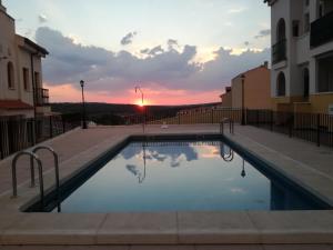 a swimming pool with the sunset in the background at MI RUIDERA in Ruidera