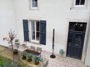 a white house with two chairs and a door at la maison de Valbois in Varvinay