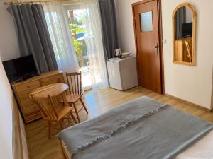 a bedroom with a bed and a table and chairs at Willa Mona in Międzywodzie