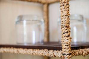 a wicker shelf with two glass jars on it at Les Gués Rivières in Pujols Gironde