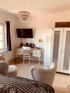 a bedroom with a bed and a desk with a television at Das Kleine Hotel Schleiblick in Schleswig