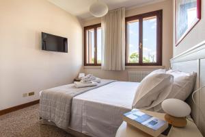 um quarto com uma cama, uma televisão e janelas em Borgo Tabari Locazione Turistica em Mussolente 