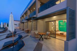 Apartamento con balcón con cama, mesa y sillas. en Lilium Luxury Suites en Agia Marina Nea Kydonias
