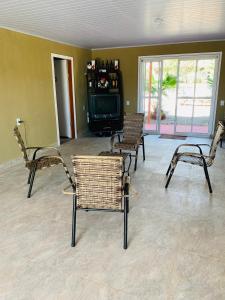 a living room with rattan chairs and a television at Repouso do Tchê in Foz do Iguaçu