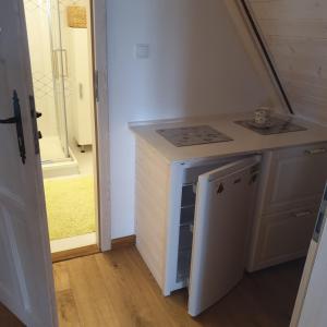 a small kitchen with a sink and a dishwasher at Malowniczy Zakątek w Dercu in Derc