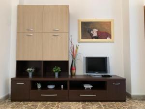 a entertainment center with a television and a cabinet at Casa Delizia in Vittoria