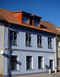 uma casa azul com um telhado vermelho em ViaNova14 em Reuterstadt Stavenhagen