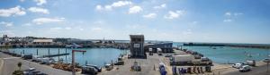a marina with cars parked next to the water at La Vigie sur le Port in Granville