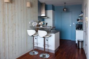 a kitchen with two bar stools and a counter at La Vigie sur le Port in Granville