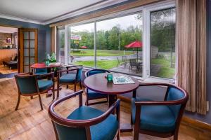 a restaurant with tables and chairs and a large window at Long Sault Motel in Long Sault
