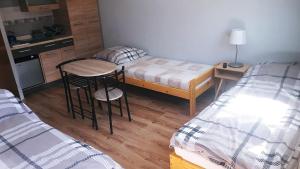 een kleine kamer met een bed, een bureau en een keuken bij Pokoje u Anastazji in Zakrzewo