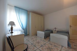 a bedroom with two beds and a desk and a chair at Casa Vacanze TITINA HOME in Montalbano +38 photos