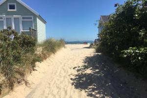 a house on the beach next to a sandy beach at Mudeford Mews in Mudeford