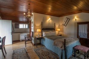 - une chambre avec un lit et un plafond en bois dans l'établissement Quintal De Alem Do Ribeiro-Turismo Rural, à Lousã