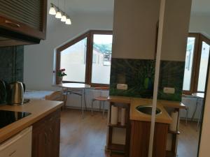 a kitchen with a sink and a table with chairs at Suwałki Centrum Apartament in Suwałki