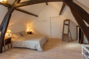 een slaapkamer met een bed en een houten vloer bij Couette & Confitures in Nojeon-le-Sec
