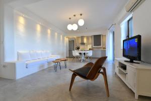 ein Wohnzimmer mit einem weißen Sofa und einem TV in der Unterkunft Infinity sea view cosy villa with private pool in Parikia