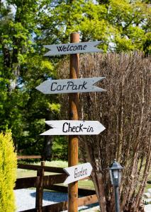 a wooden pole with street signs in a park at Birchbank in Roybridge