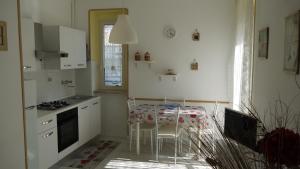a white kitchen with a table and chairs in it at Appartamento Accanto Al Faro in Vasto