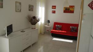 a living room with a red couch and a television at Appartamento Accanto Al Faro in Vasto